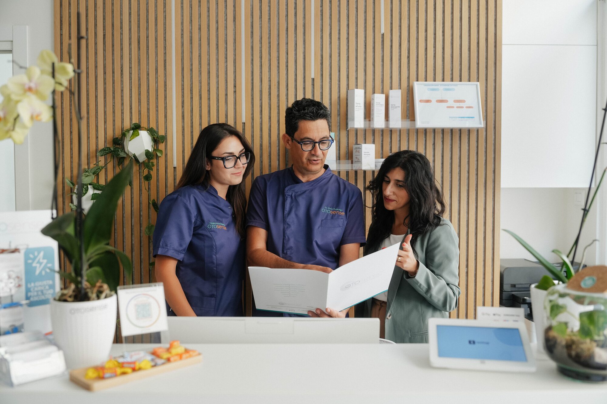Il team Otosense — Aurora Randone, Gino Flamingo e la responsabile accoglienza — al lavoro in reception.